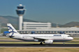 Panning shot of an Aegean Airbus 320 taking of from Athens with the MTB and control tower in the background