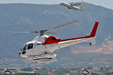 A helicopter hovering over the heliport of Athens while an Olympic ATR is taking off